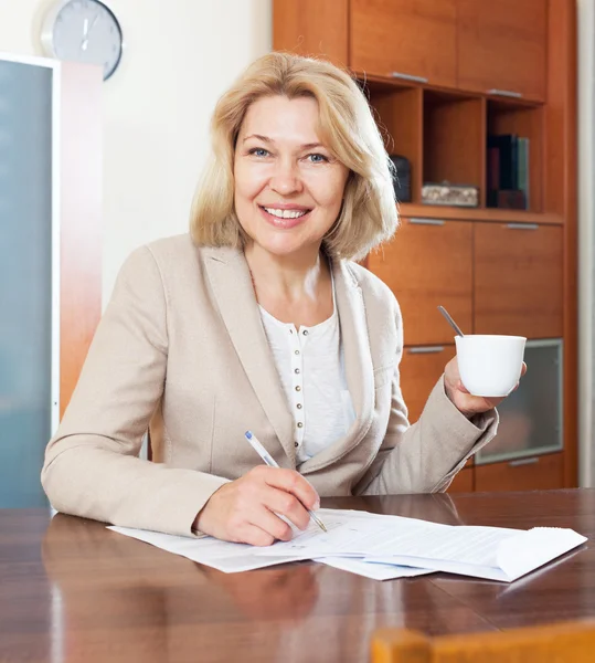 Adult woman sitting at table — Stock Photo, Image