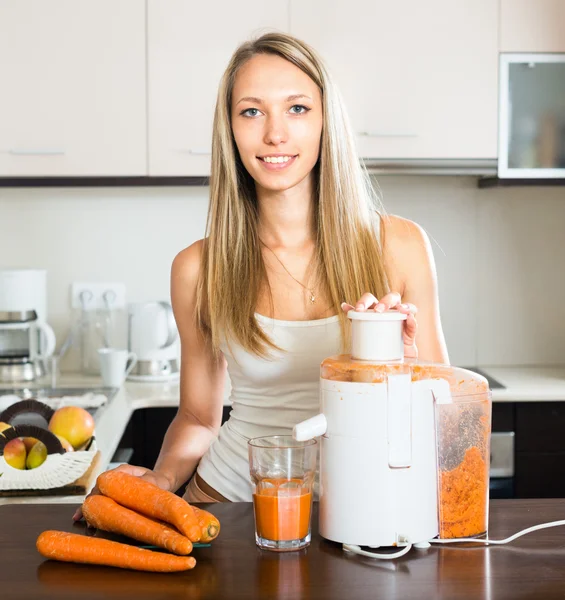 Housewife making juice from carrots — Stock Photo, Image