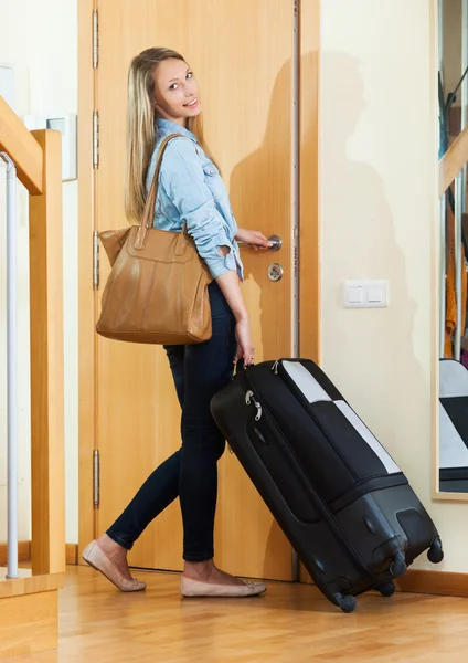 Woman with luggage near door — Stock Photo, Image