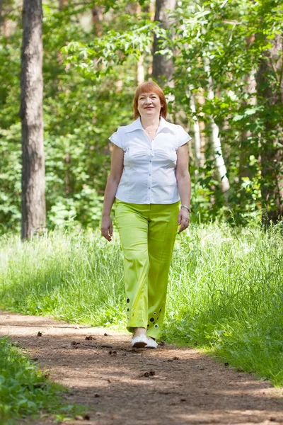 Marcher femme mûre dans la forêt — Photo