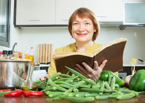 Femme mûre cuisine okra — Photo