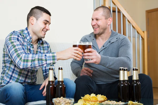 Zwei Freunde, die zu Hause Bier trinken — Stockfoto