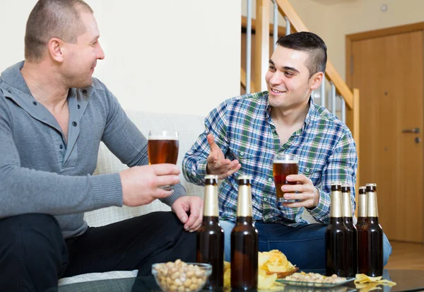 Zwei Freunde, die zu Hause Bier trinken — Stockfoto