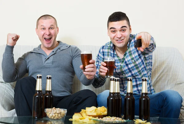 Freunde sitzen mit Bier am Tisch — Stockfoto