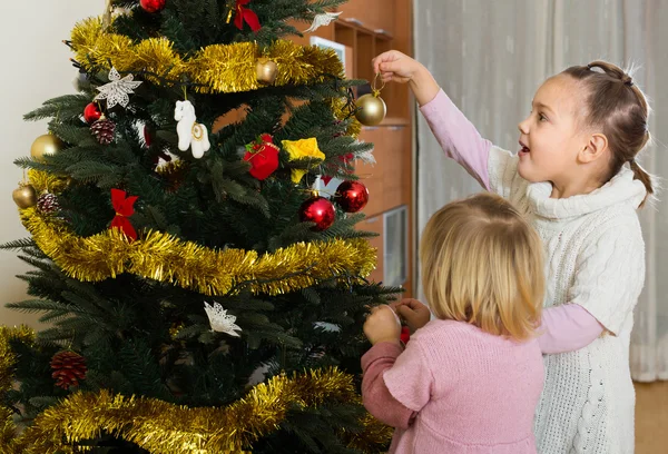 Små flickor dekorera julgran — Stockfoto