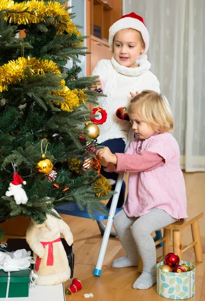 Sorelle che appendono decorazioni su abete — Foto Stock