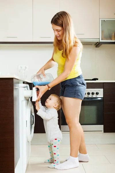Женщина и ребенок с помощью стиральной машины — стоковое фото