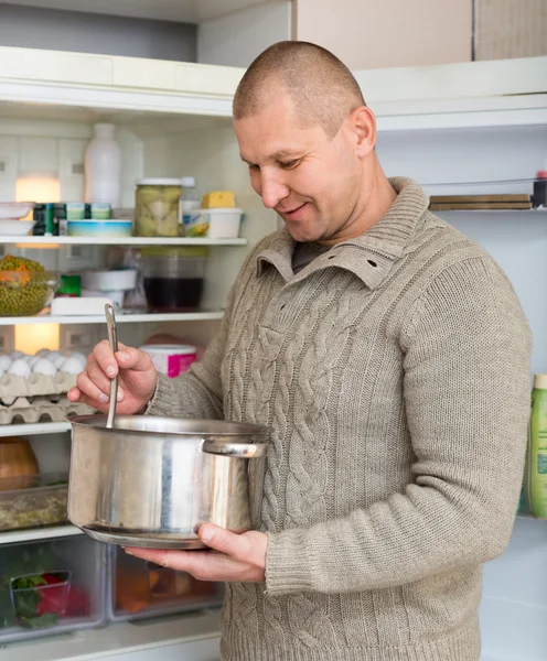 Hombre con sartén cerca del refrigerador — Foto de Stock