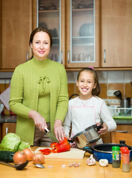 Mamma med dotter matlagning på kök — Stockfoto