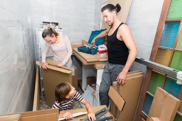 Padres con hijo desempacando cajas — Foto de Stock