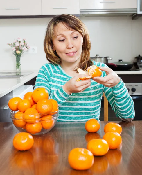 Mulher sorrindo comendo mandarinas — Fotografia de Stock