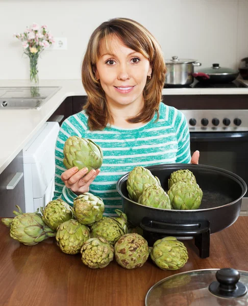 Volwassen vrouw koken artisjok — Stockfoto