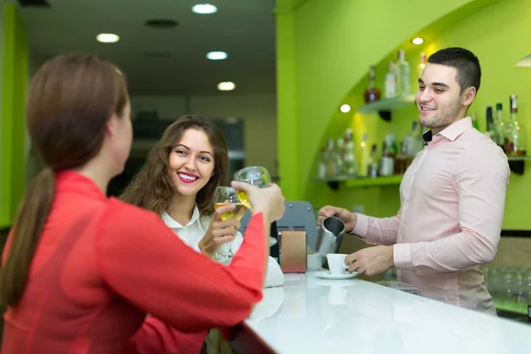 Bartender and smiling women at bar — Stock Photo, Image