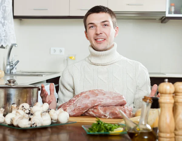 Guy cooking meat in kitchen — Stock Photo, Image