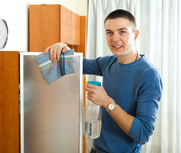 Bonito homem sorridente limpeza de vidro — Fotografia de Stock