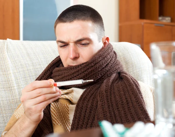 Sick  man looking at thermometer — Stock Photo, Image