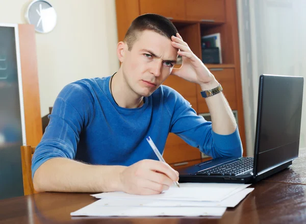 Trauriger Mann mit Laptop und Dokumenten — Stockfoto