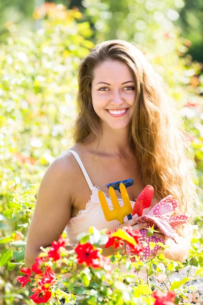 Chica en rosas planta en el jardín —  Fotos de Stock