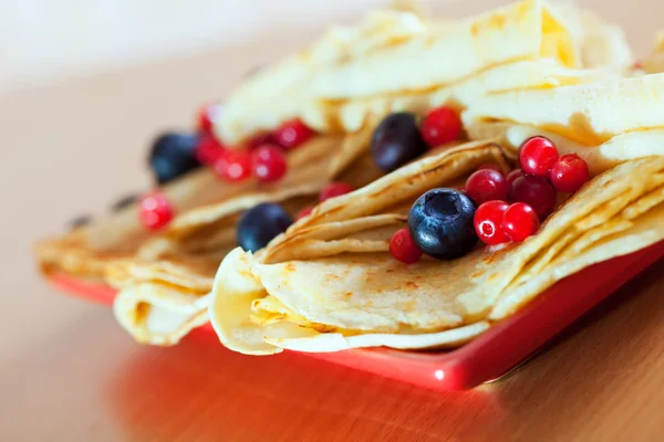 Pfannkuchen auf Teller mit Preiselbeeren und Blaubeeren — Stockfoto