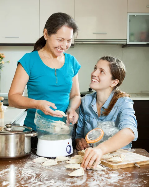 Vuxen tjej med mogen mor matlagning — Stockfoto