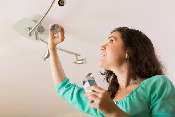 Woman changing light bulb — Stock Photo, Image