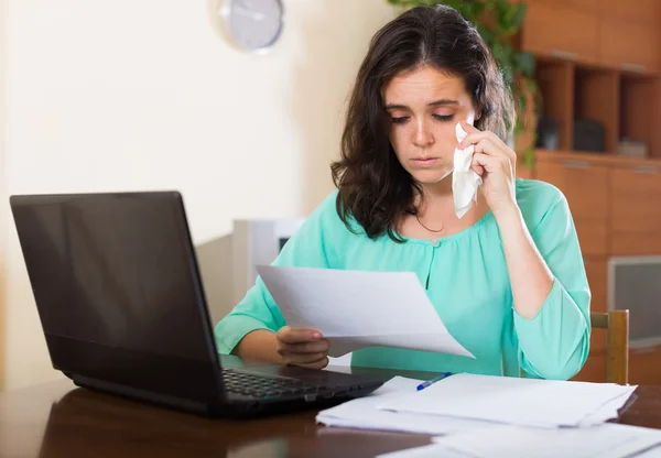 Sad woman with documents and laptop — Stock Photo, Image