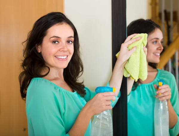 Brünette frau putzspiegel — Stockfoto