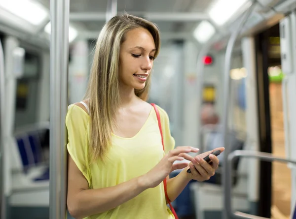 Meisje met smartphone in metro — Stockfoto
