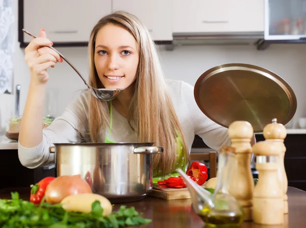 取鍋のスープをテストを持つ女性 — ストック写真