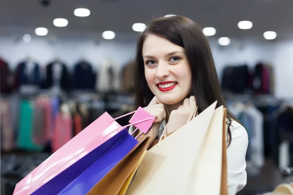 Gelukkig brunette meisje met shopping tassen — Stockfoto