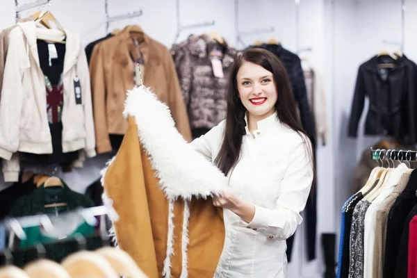 Chica elegir chaqueta en boutique —  Fotos de Stock