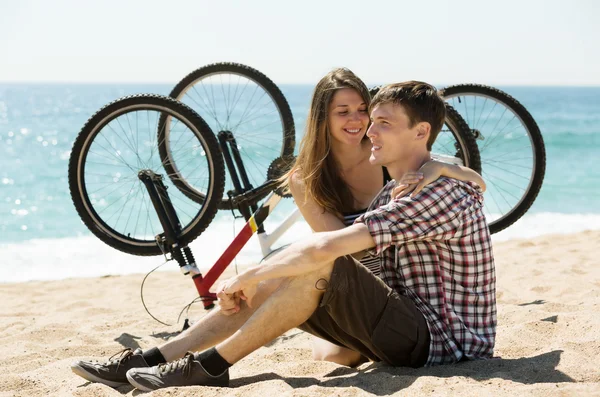 Couple with bikes on beach — Stock Photo, Image