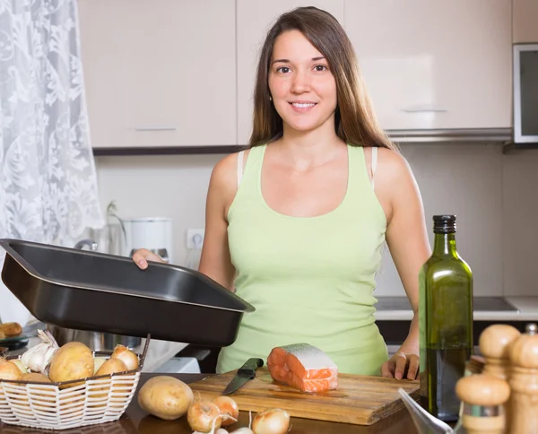 Sorrindo dona de casa cozinhar salmão — Fotografia de Stock