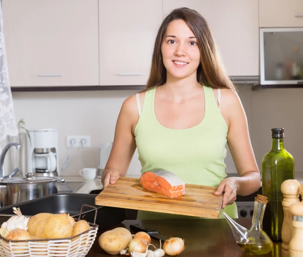 Usmívající se žena v domácnosti, vaření losos — Stock fotografie