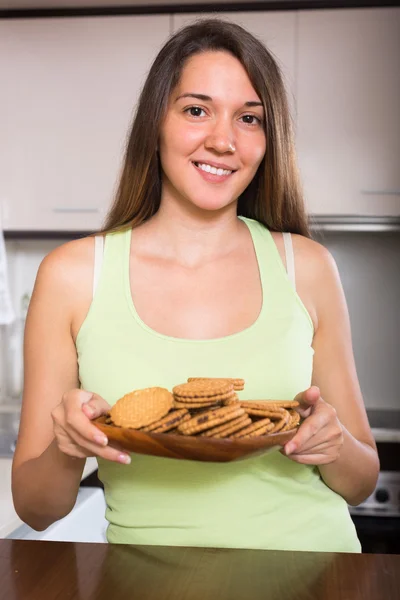 Dona de casa com biscoitos na cozinha — Fotografia de Stock