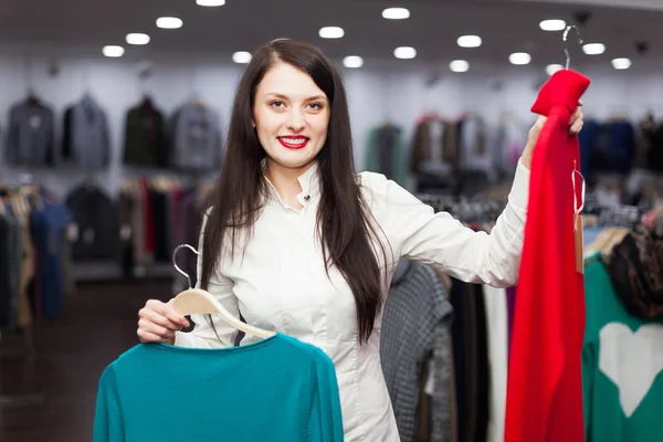 Joyful female buyer with sweaters Royalty Free Stock Images