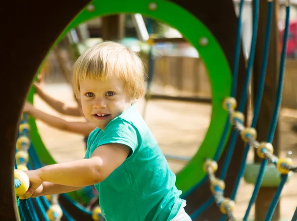 Menina bebê em verde no parque infantil — Fotografia de Stock