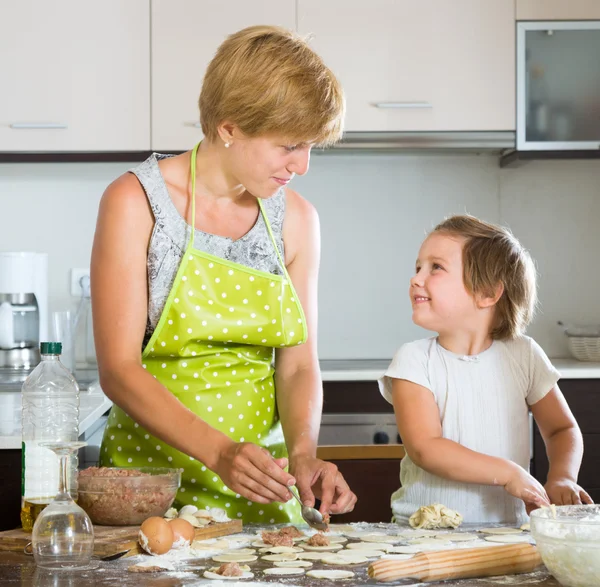 Barn med mor gör kött dumplings — Stockfoto