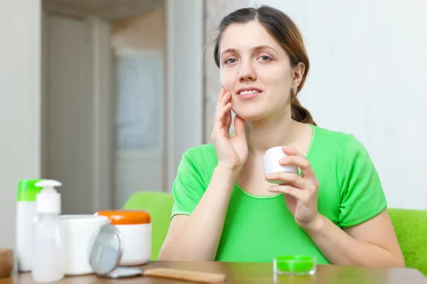 Woman in green caring for her face — Stock Photo, Image