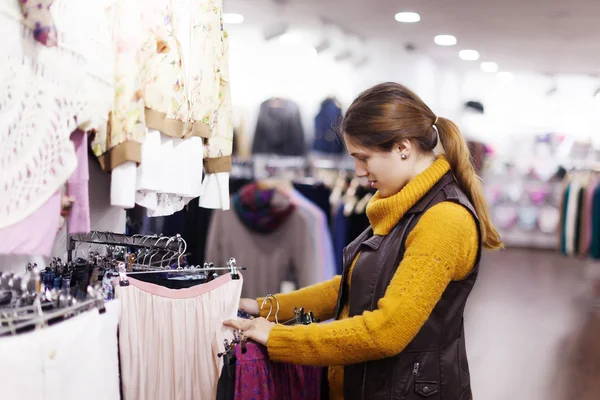 Mujer elegir ropa en la tienda — Foto de Stock