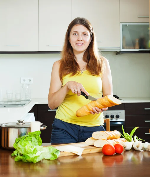 Menina feliz cozinhar sanduíches com baguete — Fotografia de Stock