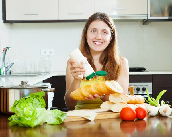 Mulher feliz cozinhar sanduíches com maionese — Fotografia de Stock