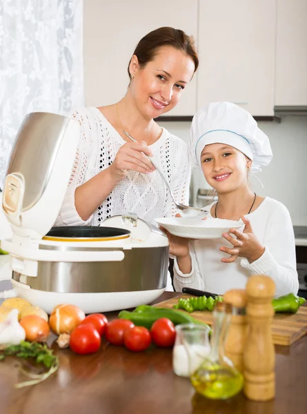 Menina e mãe com fogão de arroz — Fotografia de Stock