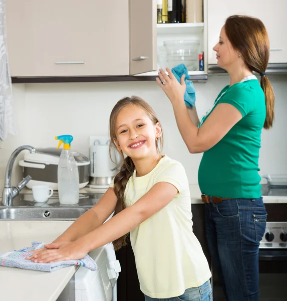 Chica y mamá ordenado cocina hasta —  Fotos de Stock