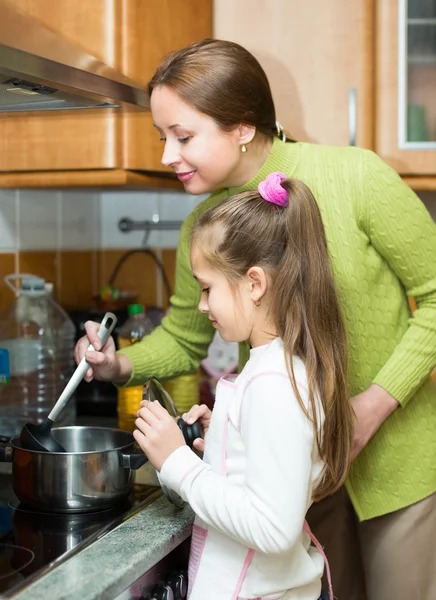 Mother with daughter cooking at kitchen — Stock Photo, Image