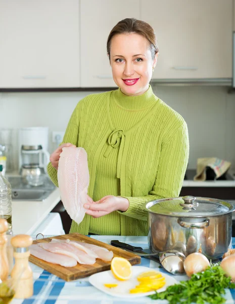 Cheerful female cooking fish — Stock Photo, Image