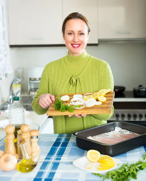 Mujer feliz cocinando pescado — Foto de Stock