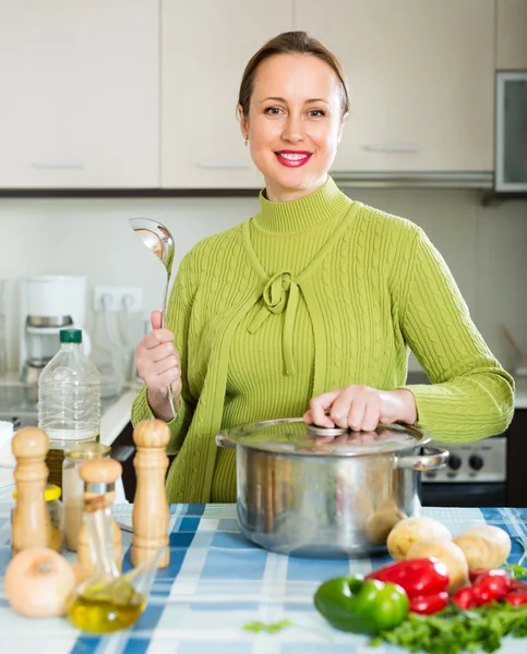 Mujer cocinando sopa en la cocina —  Fotos de Stock