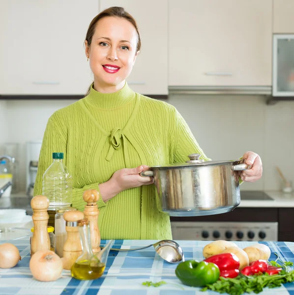 Donna che cucina zuppa in cucina — Foto Stock
