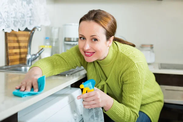 Lachende vrouw schoonmaken meubilair — Stockfoto